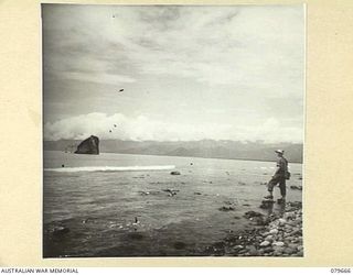 LAE, NEW GUINEA. 1943-10. THE REMAINS OF A JAPANESE VESSEL LOCATED NEAR THE AIR STRIP. MEMBERS OF THE 10TH FIELD AMBULANCE, AUSTRALIAN ARMY MEDICAL CORPS ARE LOCATED IN THE AREA