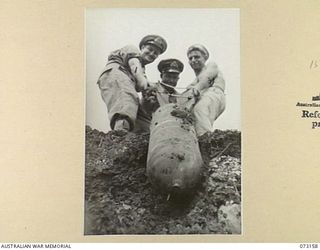 ALEXISHAFEN, NEW GUINEA. 1944-05-11. MEMBERS OF A RMSU (RENDERING MINES SAFE UNIT), RAN, HAULING TO THE SURFACE A JAPANESE 100 KILOGRAM AERIAL BOMB AT ALEXISHAFEN NO. 1 AIRSTRIP. THE BOMB WAS THE ..