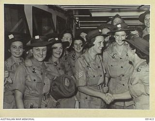 LAE, NEW GUINEA, 1945-05-07. AUSTRALIAN WOMEN'S ARMY SERVICE PERSONNEL ABOARD THE MV DUNTROON, BEING GREETED BY STAFF-SERGEANT O.M.G. EDWARDS, COMPANY QUARTERMASTER SERGEANT (6). THEY ARE AMONG ..