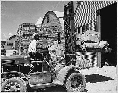 "M. D. Shore, S1/c, operating a forklift truck at the Navy supply depot at Guam, Marianas."