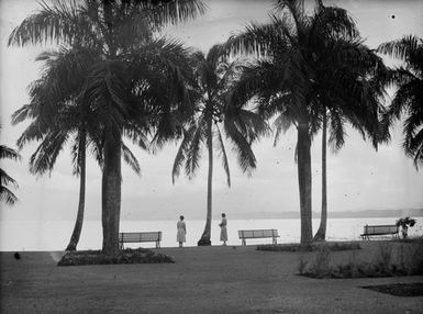 [Two women look out to sea from Pacific Island waterfront]