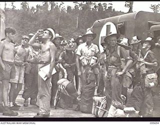 LAE, NEW GUINEA, 1946-01-29. VOLUNTEERS OF 34TH INFANTRY BRIGADE, BRITISH COMMONWEALTH OCCUPATION FORCE (BCOF), FROM FIRST ARMY AREA, LAE, WAITING ON THE WHARF TO EMBARK FOR THEIR JOURNEY TO ..