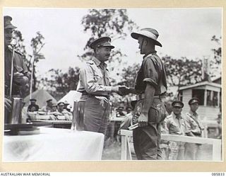 HERBERTON, QLD. 1945-01-19. LIEUTENANT GENERAL SIR LESLIE J MORSHEAD, GENERAL OFFICER COMMANDING 1 CORPS, (2), PRESENTING PRIVATE A C BIGGINS, 1 COMPANY, 2/8 FIELD AMBULANCE, (3), WITH THE PRIZE ..