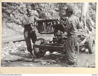 BARGES HILL, CENTRAL BOUGAINVILLE, 1945-06-26. GNR K. URWIN (1) AND L-BDR N. HEALEY (2), MEMBERS OF 2 MOUNTAIN BATTERY DISMANTLING JEEPS FOR TRANSPORTATION OVER THE RIDGE TO THE ROAD HEAD BY A ..