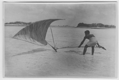 "Bock and Hessle Gilbertöarnaexpedition: 1 man with hip cladding stands in shallow water and holds 1 sport competition canoe. Text on the back: “Sports competition canoe, submitted to the Swedish Museum of Swedish Armed Forces...? department.”: Included in series with photon. 6977: 1-15. "