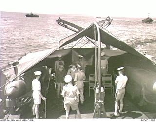 THE SOLOMON ISLANDS, 1945-08-20. AN AUSTRALIAN ARMY OFFICER BEGINS SURRENDER DISCUSSIONS WITH TWO JAPANESE OFFICERS DELIVERED ON BOARD HMAS LITHGOW OFF MOILA POINT. TWO OTHER AUSTRALIAN NAVAL ..