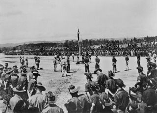 Cape Wom, Wewak, New Guinea. 1945-09-13. Watched by a large crowd of soldiers, the official party awaits the arrival of Lieutenant General Hatazo Adachi, General Officer Commanding XV111 Japanese ..