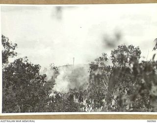 DONADABU AREA, NEW GUINEA. 1943-11-30. THE OBJECTIVE, WREATHED IN SMOKE FROM EXPLODING 25-POUNDER SHELLS PRIOR TO THE ATTACK BY THE INFANTRY DURING A COMBINED EXERCISE BY THE 2/10TH AUSTRALIAN ..