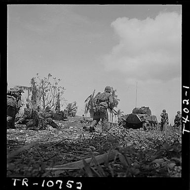 Marines advance behind tank on Guam