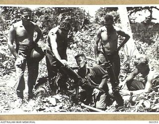 WANDOKAI, NEW GUINEA. 1944-01-01. PERSONNEL OF THE 9TH DIVISION SALVAGE UNIT EXAMINING TWO 7.7MM JAPANESE TYPE 92 MACHINE GUNS (WOODPECKERS) ABANDONED BY THE RETREATING JAPANESE FORCES. THEY ARE: ..