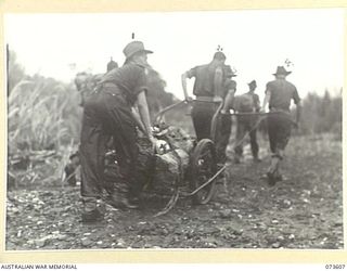 MALAS RIVER, NEW GUINEA. 1944-05-27. FORWARD TROOPS OF THE 35TH INFANTRY BATTALION PULL AN ABANDONED JAPANESE HAND CART DURING THE ADVANCE TOWARDS WEWAK. IDENTIFIED PERSONNEL ARE:- NX90702 PRIVATE ..