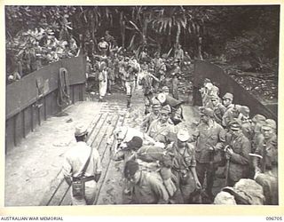 KAIRIRU ISLAND, NEW GUINEA. 1945-09-17. JAPANESE NAVAL PERSONNEL MOVING ONTO BARGE FOR TRANSFER TO MUSCHU ISLAND. THEIR GEAR HAS BEEN SEARCHED BY SECURITY PERSONNEL. FOLLOWING THE SURRENDER OF THE ..
