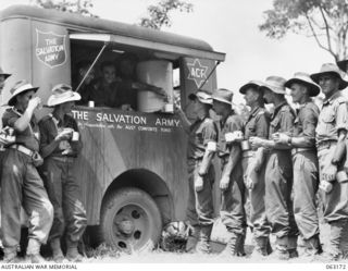 DONADABU, PAPUA, NEW GUINEA. 1944-01-01. THIRSTY SPECTATORS LINED UP AT THE SALVATION ARMY MOBILE CANTEEN DURING THE 15TH INFANTRY BRIGADE GYMKHANA. IDENTIFIED PERSONNEL ARE: SERGEANT L. J. SHAW ..