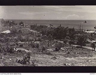 LAE, NEW GUINEA. 1943-10-04. SECTION PHOTOGRAPH OF THE WATERFRONT TAKEN FROM OBSERVATION HILL COVERS DOCK INLET ON LEFT TO BARGE AT SEA ON RIGHT. TO JOIN PHOTOGRAPHS NOS. 057974, 057975, 057976 AND ..