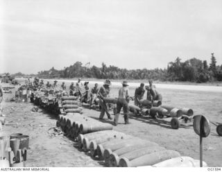 TADJI NEAR AITAPE, NORTH EAST NEW GUINEA. C. 1944-09. BOMBS BEING LOADED ONTO LOW TRAILERS FROM A DUMP NEAR AITAPE ARE HAULED TO WAITING BOMBER BEAUFORT AIRCRAFT OF NO. 8 SQUADRON RAAF. LARGE ..