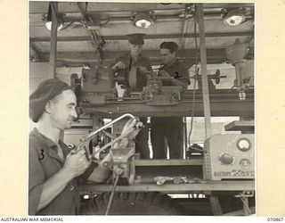 WAU, NEW GUINEA, 1944-02-20. NX18125 CAPTAIN A.J. SEARLE, OFFICER COMMANDING THE 2/34TH GENERAL TRANSPORT COMPANY WORKSHOPS (1), PICTURED WITH NX28943 STAFF SERGEANT W.J. BOWMAN (2), AND NX67792 ..
