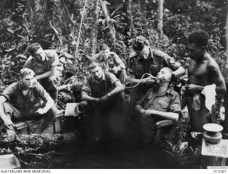 1943-07-14. NEW GUINEA. WAU-MUBO AREA. A DENTAL CLINIC POST IN A FORWARD AREA. CAPT. J. GRAY, OF OATLEY, N.S.W. GIVES TREATMENT TO PTE. G. VERITY OF NARRABEEN, N.S.W. THIS DENTAL POST IS WITHIN ..