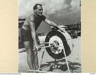 TOROKINA, BOUGAINVILLE, 1944-11-19. LEADING AIRCRAFTMAN G.M. CONNOR, ROYAL NEW ZEALAND AIR FORCE, WHITH THE REEL WHICH HIS TEAM USED DURING THE SURF CARNIVAL ORGANISED BY HEADQUARTERS, 3RD ..