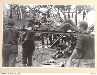 BOUGAINVILLE. 1945-04-06. A JAPANESE PRISONER OF WAR BEING CARRIED BY 25 INFANTRY BATTALION STRETCHER BEARERS FOR TREATMENT AT THE REGIMENTAL AID POST AFTER THE ACTION ON SLATER'S KNOLL