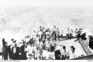 NAURU, PACIFIC ISLANDS. 1942-02. CIVILIANS EVACUATED FROM NAURU AND OCEAN ISLAND BY THE FREE FRENCH DESTROYER LE TRIOMPHANT IN BOATS ALONGSIDE THE SHIP. (NAVAL HISTORICAL COLLECTION)