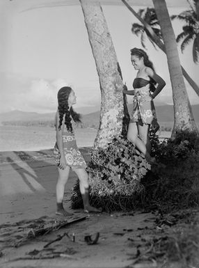 [Two Pacific Island girls on a shoreline]