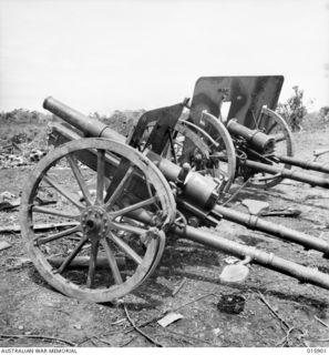 1943-10-02. NEW GUINEA. LAE. SMASHED JAPANESE FIELD GUNS AMONGST THE WRECKAGE, OF WHAT WAS ONCE LAE. (NEGATIVE BY MILITARY HISTORY NEGATIVES)