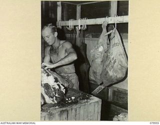 STIRLING ISLAND, TREASURY GROUP. 1945-03-21. VX135261 PRIVATE K.W. GATHERCOLE (1), UNIT BUTCHER, 7TH INFANTRY BATTALION, CUTS MEAT FOR THE KITCHEN