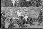 Pig festival, singsing, Kwiop: Ed Cook and Nancy Cook rest on makeshift bench