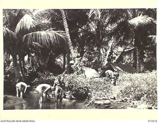 SARANG, NEW GUINEA. 1944-05-25. MEMBERS OF THE 35TH INFANTRY BATTALION WASHING IN A STREAM. THEIR CAMP LIES IN THE BACKGROUND. IDENTIFIED PERSONNEL ARE:- NX120433 PRIVATE C.A HUMPHRIES (1); ..