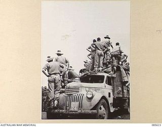 HERBERTON RACECOURSE, WONDECLA, ATHERTON TABLELAND, QLD. 1945-01-19. SPECTATORS AT HQ 9 DIVISION WATCHING ATHLETIC EVENTS DURING THE 9 DIVISION GYMKHANA FROM AN ARMY TRUCK