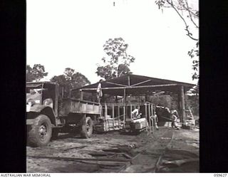 DONADABU, NEW GUINEA. 1943-11-09. TRUCKS WAITING TO TAKE ABOARD A CONSIGNMENT OF TIMBER AT THE 9TH AUSTRALIAN WORKSHOP AND PARK COMPANY, ROYAL AUSTRALIAN ENGINEERS EILOGO SAWMILL