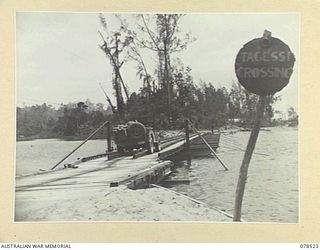 BOUGAINVILLE ISLAND, 1945-01-19. AN AUSTRALIAN ARMY JEEP CROSSING THE TEMPORARY FLOATING BOAT BRIDGE ACROSS THE TARGESSI RIVER