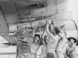 TADJI NEAR AITAPE, NORTH EAST NEW GUINEA. C. 1944-10. MEMBERS OF NO. 8 (BEAUFORT) SQUADRON RAAF ATTACHING A BOMB TO A RACK OF ONE OF THE SQUADRON AIRCRAFT