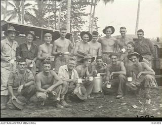 AITAPE, NORTH EAST NEW GUINEA. C. 1944-06. GROUP PORTRAIT OF ENGINEERS OF NO. 7 MOBILE WORKS SQUADRON RAAF, WHO ARE BUILDING A BRIDGE ACROSS THE RAIHU RIVER, AND HAVE KNOCKED OFF FOR A CUP OF TEA