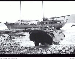 LAE, NEW GUINEA. 9 JULY 1944. A UNITED STATES ARMY AMPHIBIOUS "DUKW" LEAVING THE WATER WITH A LOAD OF SUPPLIES. IN THE BACKGROUND CAN BE SEEN THE SAILING VESSEL AK 95 OF THE 12TH SMALL SHIPS ..
