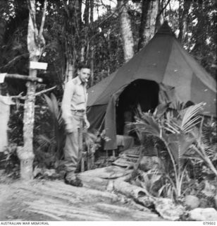 LAUNCH JETTY, NEW GUINEA: 1943-12. VX90981 CAPTAIN A.C. REITH, 10TH FIELD AMBULANCE OUTSIDE THE REGIMENTAL AID POST OF THE UNIT A.D.S. LAUNCH JETTY (ADVANCED DRESSING STATION, LAUNCH JETTY)