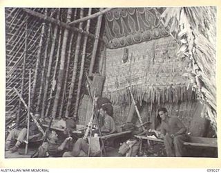 SAIGORA, NEW GUINEA. 1945-08-05. TROOPS OF 2/7 INFANTRY BATTALION TAKING THE ADVANTAGE OF A NATIVE HUT TO QUARTER THEMSELVES DOWN FOR THE NIGHT