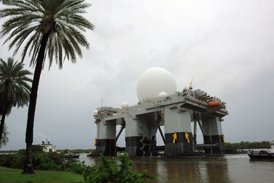 The Sea Based X-Band Radar (SBX) gets an escort from commercial tugboats, as it departs Pearl Harbor, Hawaii (HI) after a three-month port visit. The SBX arrived to undergo minor modifications, post-transit maintenance and routine inspections. The on-board propulsion system allows the SBX to transit to its homeport in Adak, Alaska in the Aleutian Islands. The SBX will provide the nation with highly advanced ballistic-missile detection