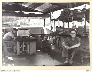 LABU, NEW GUINEA. 1944-12-18. 55 PORT CRAFT COY PERSONNEL IN THEIR LIVING QUARTERS ON A COASTAL BARGE ABOUT 5 MILES SOUTH OF LAE, RELAXING AT THE END OF THEIR DAYS WORK