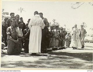 MADANG, NEW GUINEA. 1944-10-29. ALLIED TROOPS RECEIVING COMMUNION DURING A SOLEMN HIGH MASS CELEBRATED ON THE LOCAL SPORTS OVAL