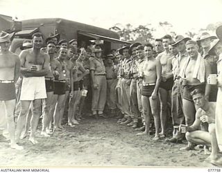 MALAHANG BEACH, LAE, NEW GUINEA. 1944-12-31. B2/304 MAJOR BROOKES, DEPUTY ASSISTANT COMMISSIONER, SALVATION ARMY, LAE AND MAJOR GATES, SALVATION ARMY COMMISSIONER, 1ST AUSTRALIAN ARMY WITH A LARGE ..