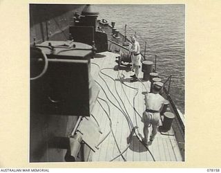 MIOS WUNDI, DUTCH NEW GUINEA. 1944-11-15. RATINGS CHECKING THE REWINDING WIRE ROPES ON THE WINCH DRUM ABOARD THE ROYAL AUSTRALIAN NAVY VESSEL HMAS KIAMA