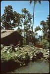 Woman sitting on a rock, in front of building