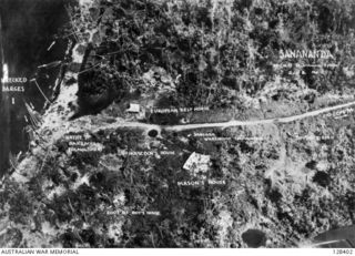 SANANANDA, BUNA AREA. 1944-01. AERIAL VIEW OF THE DAMAGED SETTLEMENT. ITS FALL MARKED THE END OF THE FIGHTING IN PAPUA, AND THE END OF AN EXPERIENCE WHICH NONE OF THE HARDENED SOLDIERS WHO SURVIVED ..