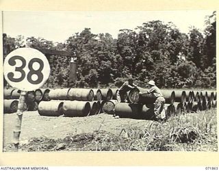 LAE, NEW GUINEA. 1944-03-30. MEMBERS OF THE 54TH BULK ISSUE PETROL AND OIL DEPOT PLATOON IN ONE OF THE CORRECTLY STACKED PETROL DISPERSAL BAYS. EACH DISPERSAL BAY IS LIMITED TO 300 DRUMS AND KEPT A ..