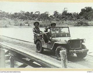 TOKO, BOUGAINVILLE, SOLOMON ISLAND. 1945-03-26. PHOTOGRAPHERS AND WAR CORRESPONDENTS CROSS THE PURIATA RIVER ON THE OLD MCKINNA BRIDGE TO RECORD THE VISIT OF VX1 GENERAL SIR THOMAS BLAMEY, GBE, ..