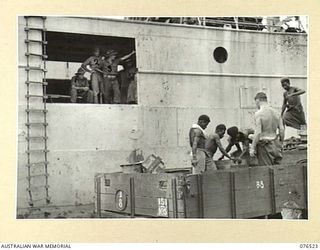 MILFORD HAVEN, LAE, NEW GUINEA. 1944-10-04. TROOPS OF THE 36TH INFANTRY BATTALION AND NATIVES LOADING STORES ABOARD THE DUTCH TROOPSHIP, "SWARTENHONDT". IDENTIFIED PERSONNEL ARE:- PRIVATE C.W. ..