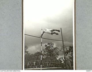 NEW GUINEA. 1943-11-20. QX23067 PRIVATE T. J. HOGAN CLEARING THE BAR IN THE POLE VAULT AT THE CHAMPIONSHIP SPORTS MEETING ORGANISED BY THE 18TH AUSTRALIAN INFANTRY BRIGADE TO CELEBRATE THE FOURTH ..