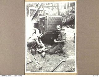 BULLDOG-WAU ROAD, NEW GUINEA. 1944-01-23. WX11687 SAPPER W.D. THOMAS, LEFT (1) AND VX35449 SAPPER R.R. MCNAIR (2) OF THE 2/4TH FIELD SQUADRON WORKING ON A D4 BULLDOZER A THE 28 MILE CAMP