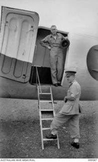 LAE, NEW GUINEA, 1945-12-25. THE RIGHT HONOURABLE J. B. CHIFLEY, PRIME MINISTER OF AUSTRALIA, AT THE DOORWAY OF THE RAAF DOUGLAS C47 DAKOTA AIRCRAFT SAYING GOODBYE TO LIEUTENANT-GENERAL H. C. H. ..
